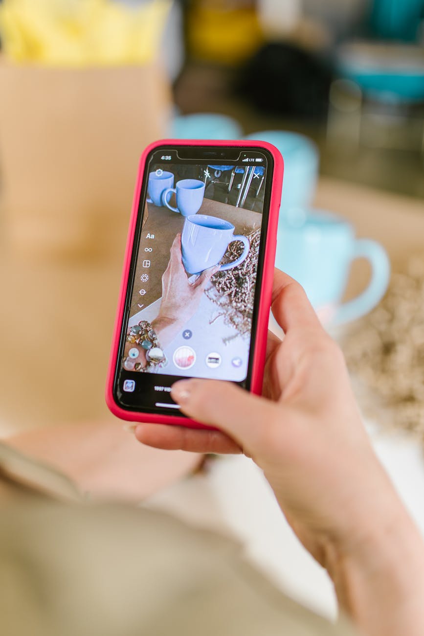 a person taking a picture of a mug using a smartphone